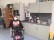 Ein Mädchen im Rollstuhl steht vor einer Küchenzeile.